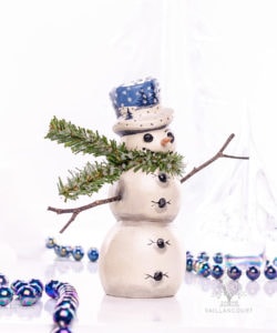 Wind Blown Snowman with Stick Arms And Blue Winter Hat